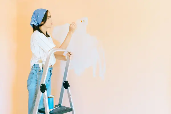 Interior painting in Norfolk: painter on a stepladder rolling a wall